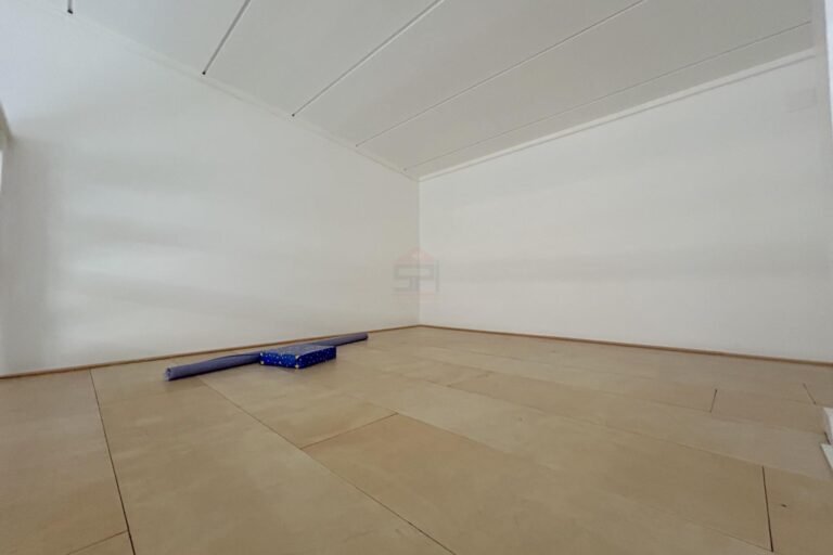 Leerer heller Raum mit Holzoptik-Boden