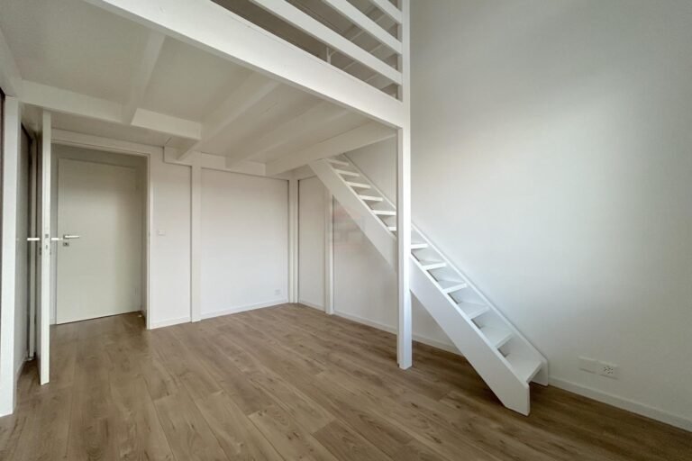 Heller Raum mit Schlafgalerie und Holztreppe